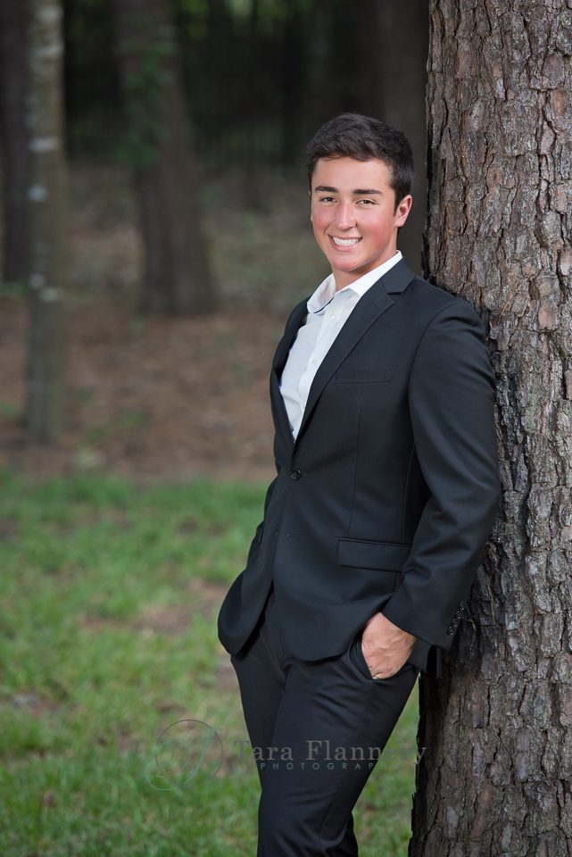 Senior Picture poses boy in suit leaning against tree