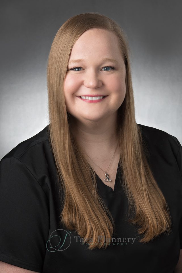 medical professional in black scrubs headshot