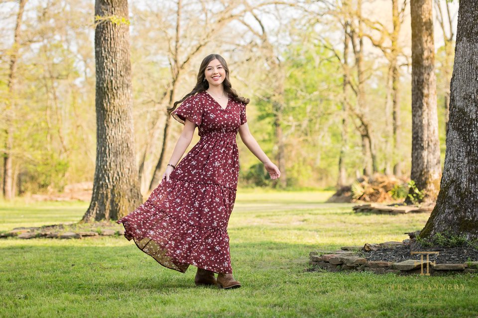 senior girl twirling in maroon dress