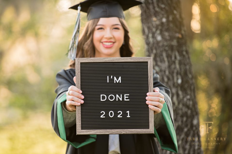 senior with sign saying I'm done 2021