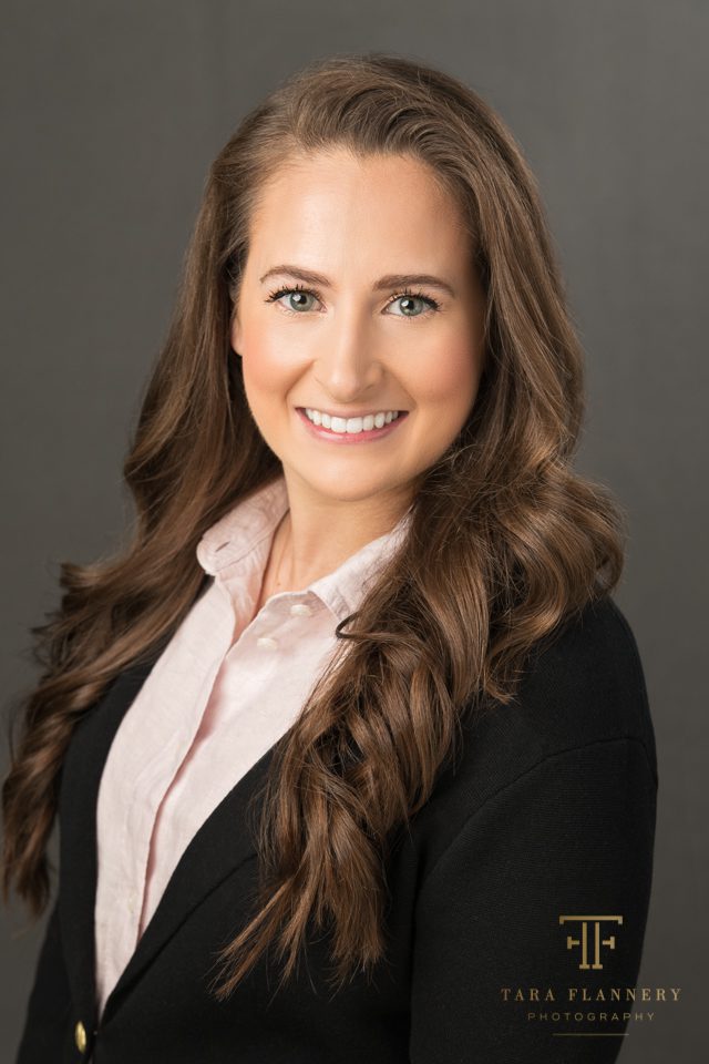 professional woman's headshot with black jacket and pink shirt