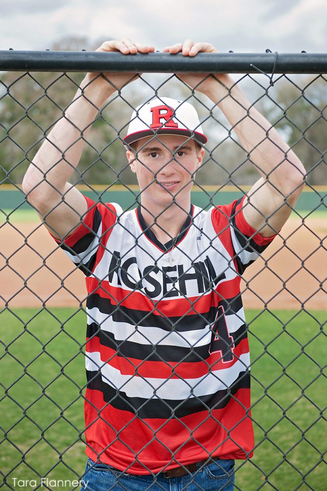 Senior boy behind fence