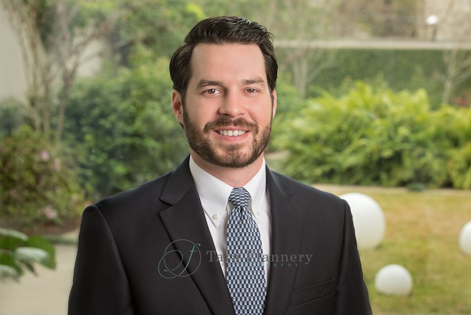 headshot of man in suit with outdoor background