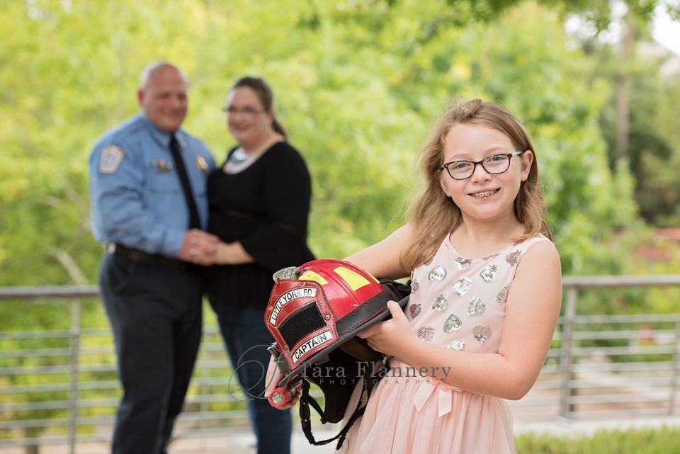 family portrait little girl with Dad's fire captain helmet