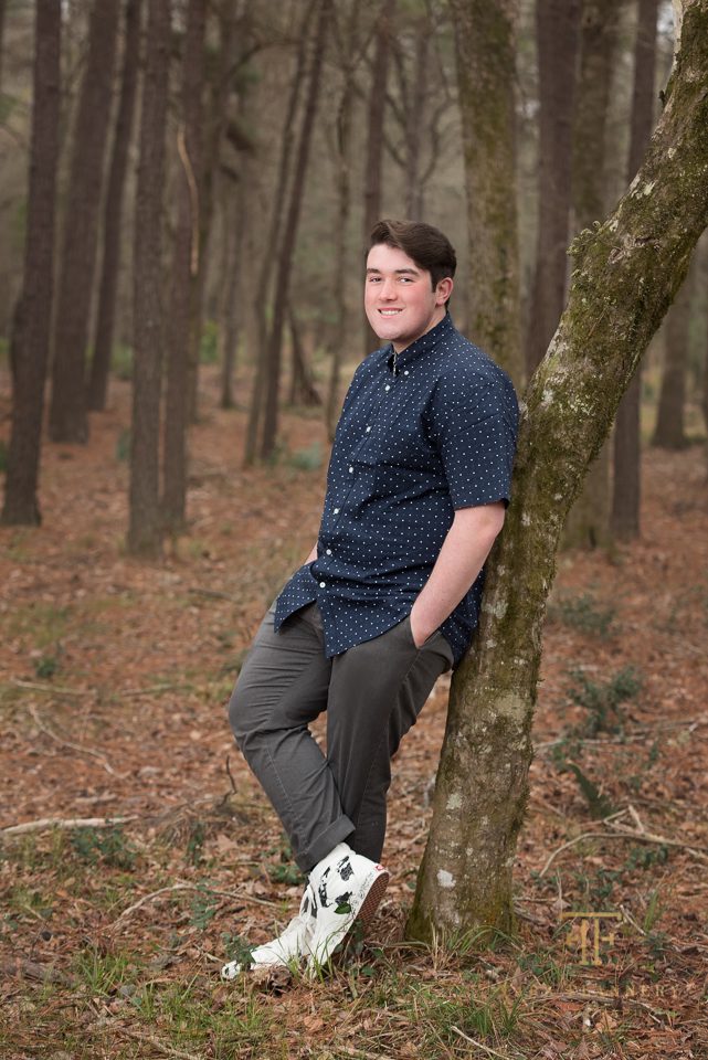 high school senior guy posing by tree