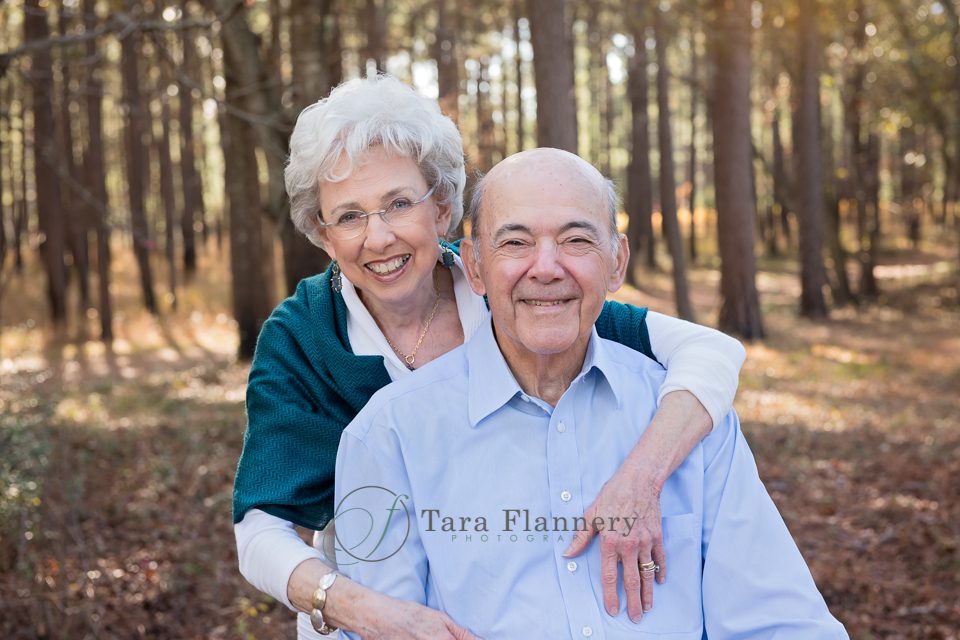 grandparents pose during family portrait session in the woods