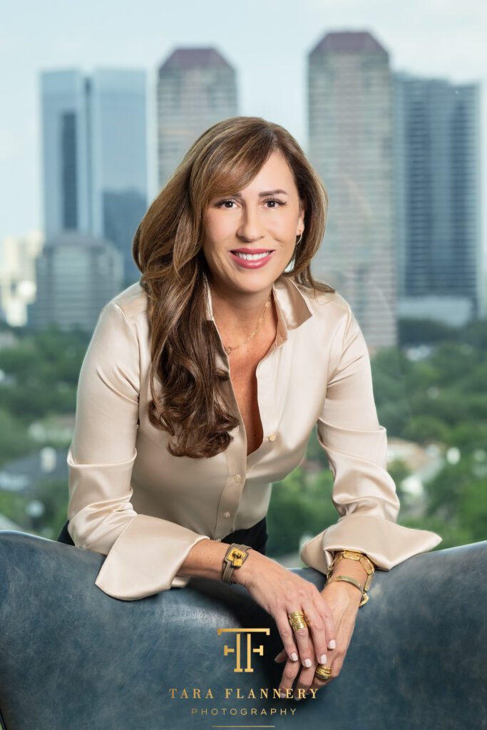 Houston realtor smiling with downtown skyline in the background for a branding photo.