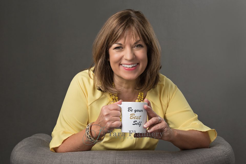 woman sitting in chair holding coffee mug