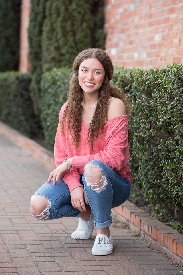 high school senior girl in pink top and jeans