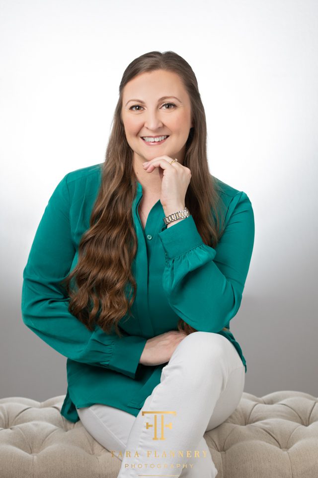 Headshot Tips on Wardrobe woman sitting with green blouse and white pants