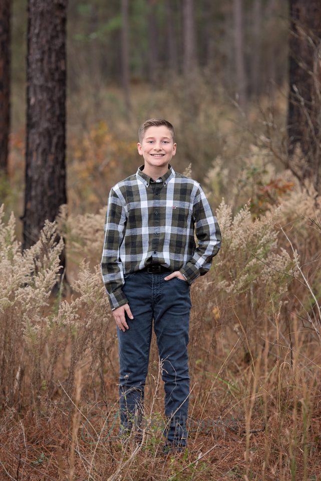 young man posed in woods during family photos