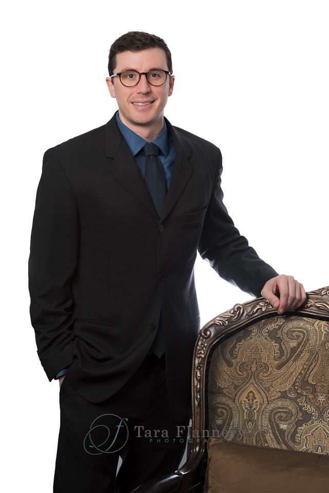 Headshot example with white background and chair prop