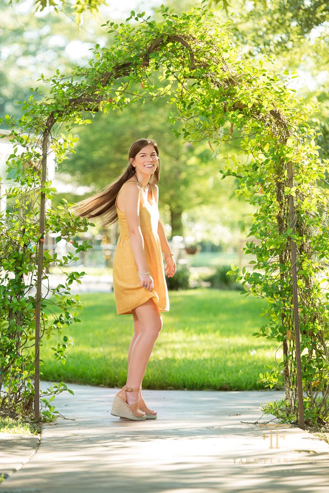 senior girl in yellow dress spinning