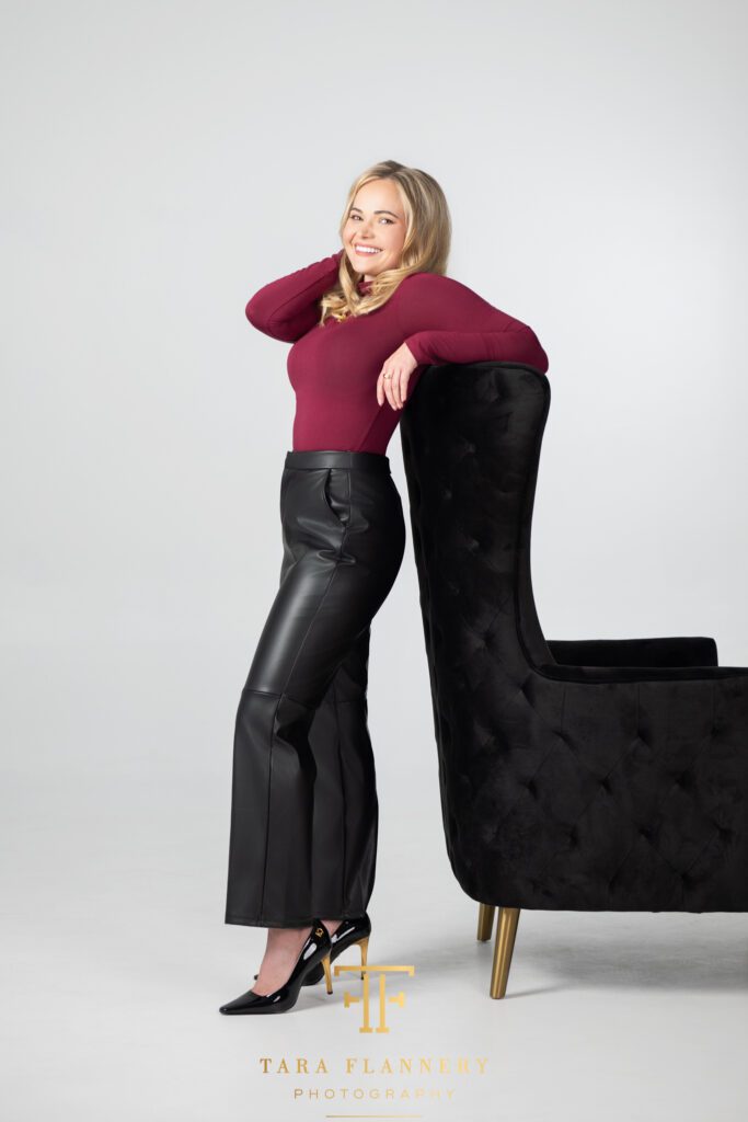Woman in black leather pants smiling for a branding session photo.