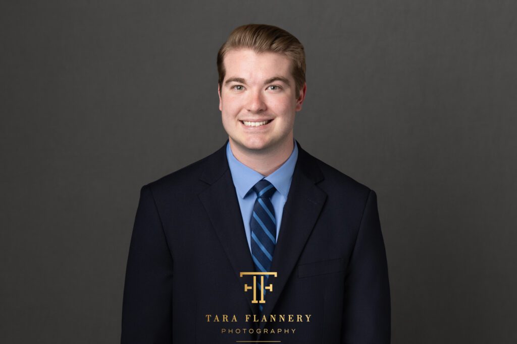 Young professional financial advisor in suit and tie for a business headshot.