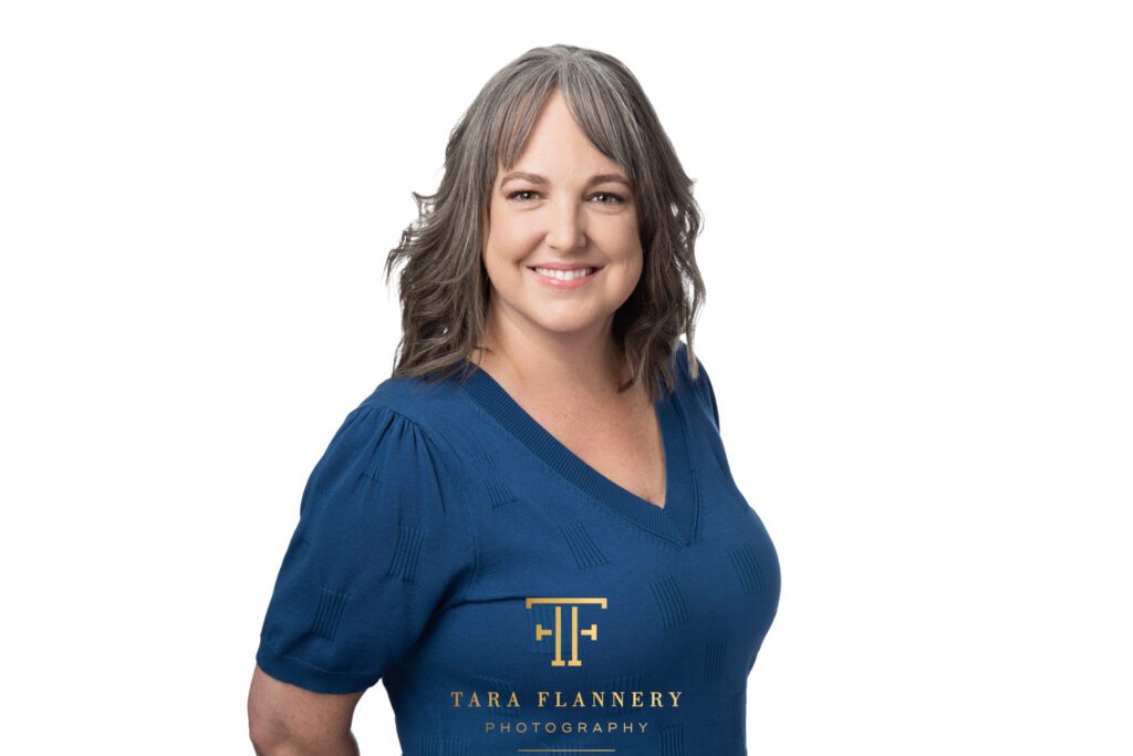 Business woman smiles for camera in her professional headshot.