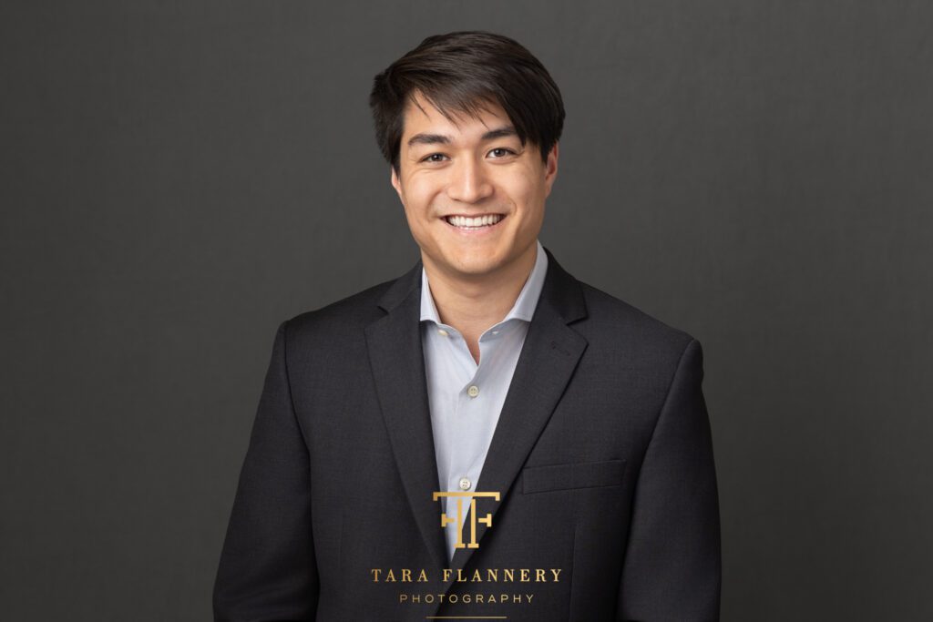 Business corporate headshot for man in dark grey suit.