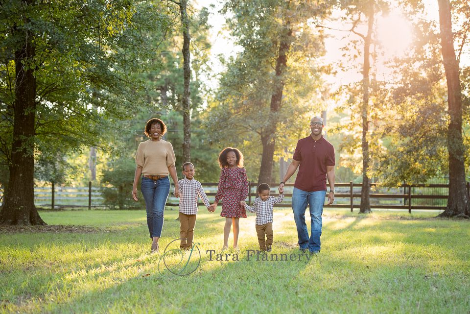 Family walks together during their outdoor family portrait session in The Woodlands Texas.