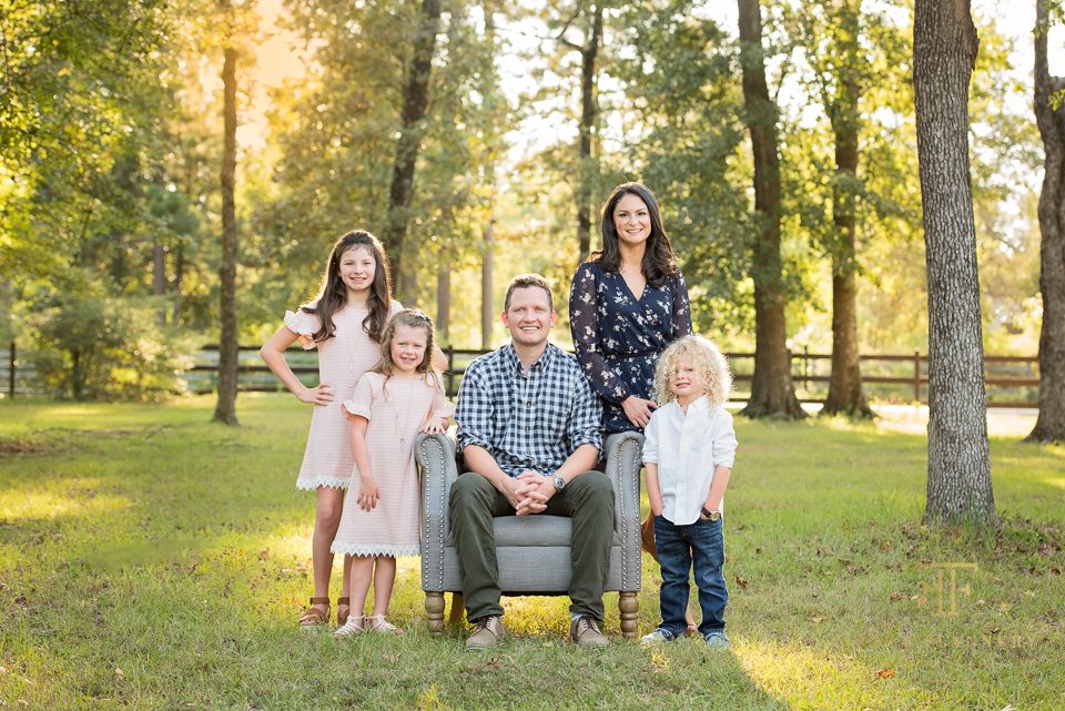 Family smiles at the camera during their outdoor family portrait session in The Woodlands TX.