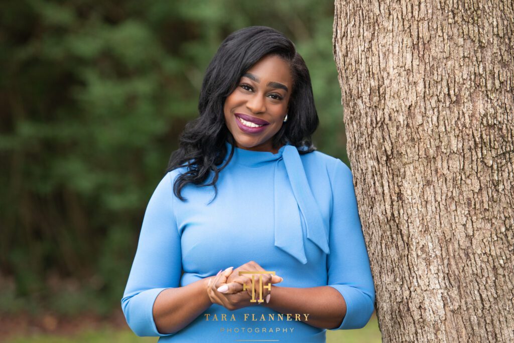 Female therapist poses outdoors for a professional environmental headshot.